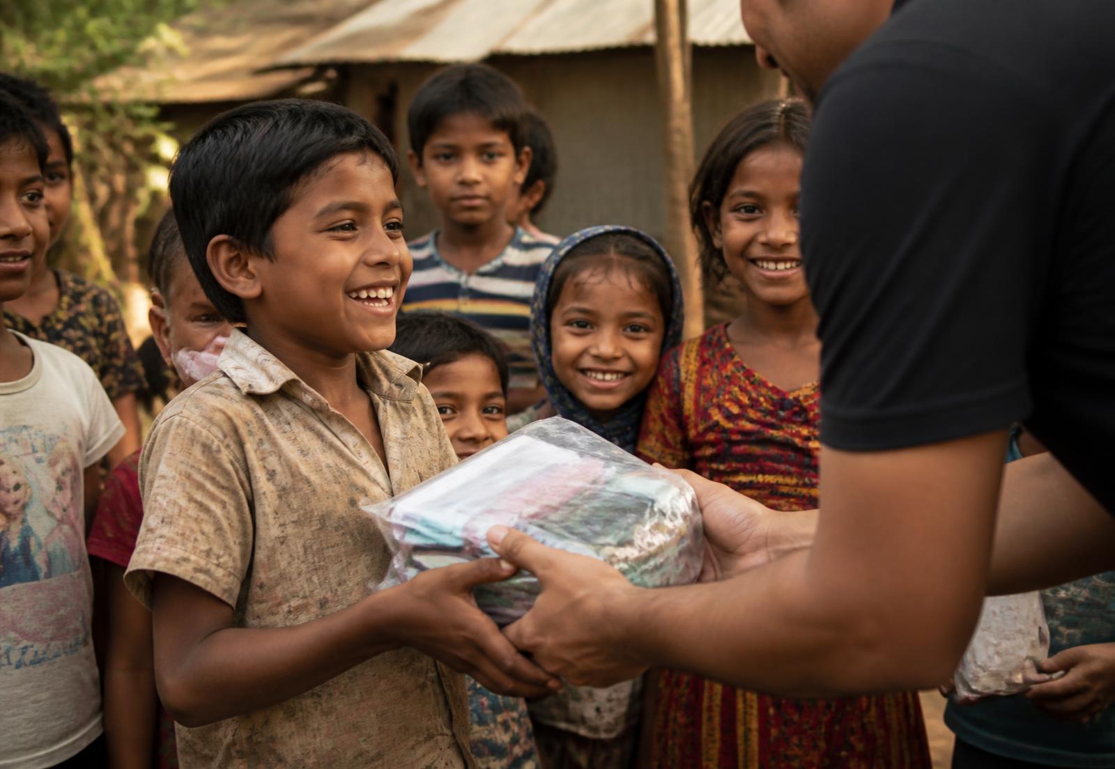 Children in a rural village receiving care packages from a volunteer